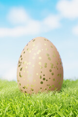 Brown Easter egg with a pattern in gold circles in a meadow in the grass. 3d render.