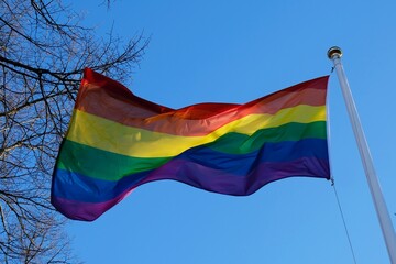 Fluttering rainbow flag on blue sky background, Stockholm, Sweden