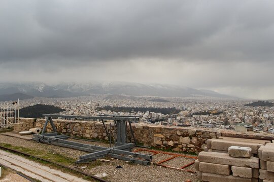 View on Athens streets from Pantheon on winter during cloudy cold day with snow on the mountain in background