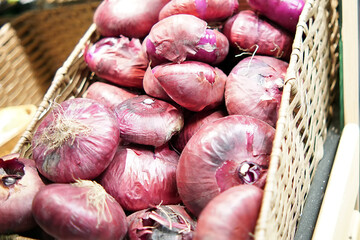 Red or purple onion lies in a rectangular basket for the sale - Powered by Adobe