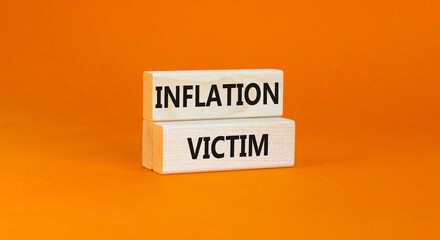 Inflation victim symbol. Concept words Inflation victim on wooden block. Beautiful orange table orange background. Business inflation victim concept. Copy space.