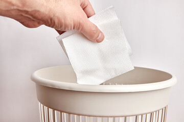 Paper napkins are thrown into the trash. Paper disposal and recycling. - obrazy, fototapety, plakaty