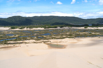 Las personas se están bañando en un pequeño pozo en las dunas de Joaquina en la Isla de Florianópolis en Brasil.