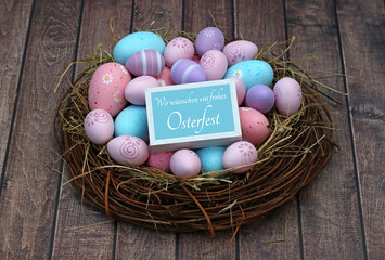  Nest mit mit pastellarbenen Ostereiern und dem Text Wir wünschen ein frohes Osterfest.