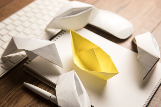 Notepad, paper boats and keyboard