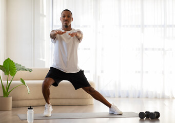 Motivated black man doing workout at home, copy space