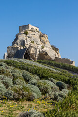 Tour Sarrasine sur son rocher, en contrebas du château fort de Baux-de-Provence, à côté d'une reconstitution d'un bélier (engin de siège)