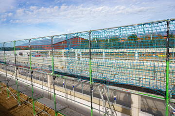 Sicherheitsma&szlig;nahmen auf einer Baustelle wo ein neuer Schweinestall entsteht, Netze werden gezogen.