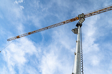 Baubranche - riesige Kräne mit Flutlicht, damit morgens und abends sicher gebaut werden kann.