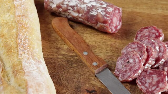 saucisson sec tranch&eacute; en gros plan sur une table en bois	