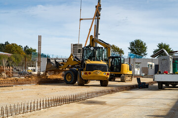 Baubranche - kleiner Bagger erledigt Erdaushebungen auf einer Baustelle.