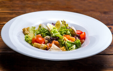 Salad with salmon and vegetables in a white plate
