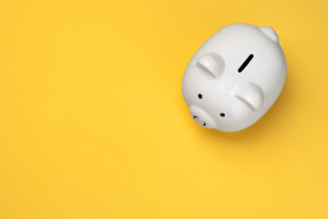 White piggy bank viewed from the top on yellow background