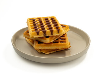 Chocolate waffles on a plate isolated on white background. Waffles in chocolate. Close-up.