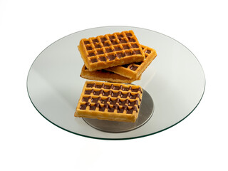 Chocolate waffles on a glass tray isolated on a white background. Wafers in chocolate. Close-up.