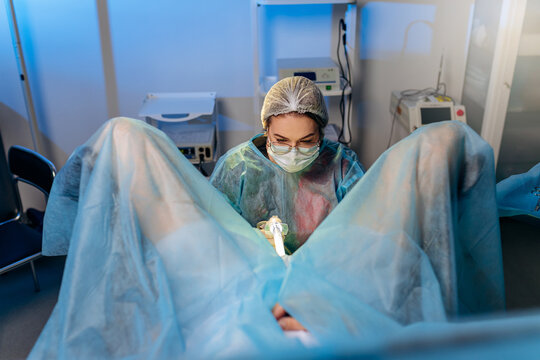 Professional female surgeon proctologist performing operation using special devices for colonoscopy in the operating room in hospital. Urgent surgical concept