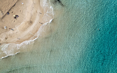 Fototapeta na wymiar Drone aerial of people relaxing in a sandy beach in winter. Fig tree bay beach, holiday resort Protaras Cyprus.