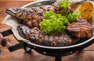 Different grilled steaks on a big bowl.