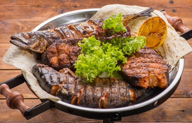 Different grilled steaks on a big bowl.
