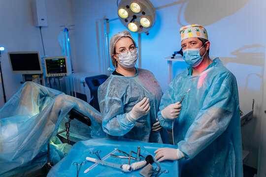 Team of professional surgeons proctologist holding scalpel and anoscope in operation room at hospital. Medical and pharmaceutical concept. Scalpel surgeon's scissors, just before surgery