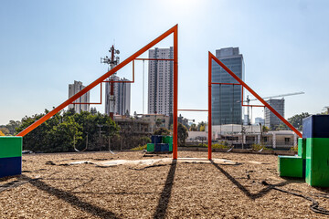 Fototapeta na wymiar Playground with empty swings in shopping center with buildings in blurred background against a blue sky, family public area for entertainment, sunny day in the city of Guadalajara, Jalisco Mexico