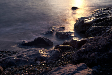 Obraz premium Line of stones from the coast at sunrise