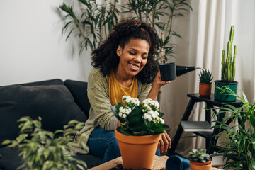 Happy relaxed woman is looking t her plants