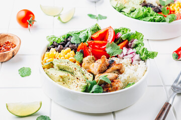 Mexican chicken burrito bowl with rice, beans, tomato, avocado,corn and lettuce. - obrazy, fototapety, plakaty