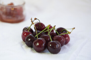 Group of Fresh delicious dark red cherry fruits and marmalade on a wooden table