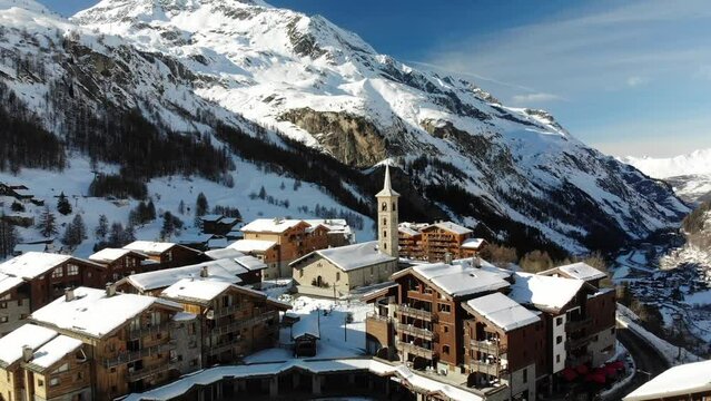 Fly around traditional French Alp village in beautiful snow winter conditions, around central Church