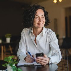 One woman mature female entrepreneur use smartphone phone at work