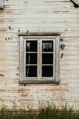 Window of old abandoned white wooden house.