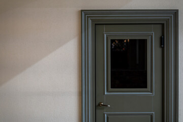 View of the closed door of the evacuation exit from the building during a fire or other cataclysm. Emergency fire exit from the building. A closed door inside an office or cafe.