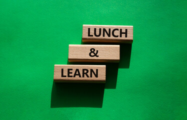 Lunch and learn symbol. Concept words Lunch and learn on wooden blocks. Beautiful green background....