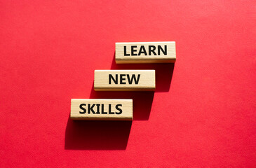 Learn new skills symbol. Concept words Learn new skills on wooden blocks. Beautiful red background. Business and Learn new skills concept. Copy space.