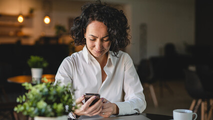 One woman use smartphone mobile phone while sit at cafe or restaurant