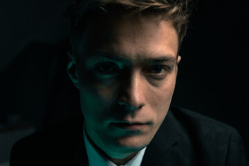 A man in a dark room is struck with grief