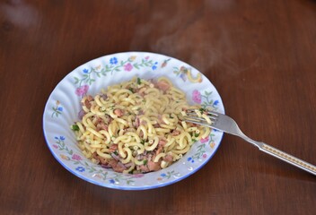 pasta with meat in a plate on a wooden table