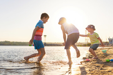 Cute kids having fun on the sandy beach in summer