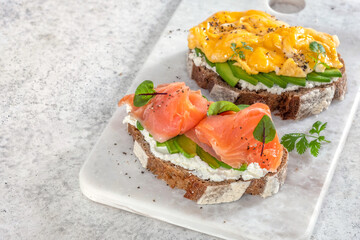 Scrambled eggs with smoked salmon, cream cheese and avocado on toast , Breakfast food