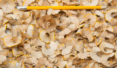 Pencils being sharpened  and collection of wood shavings.