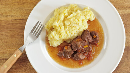 noix de joue de porc cuisiné et purée dans une assiette