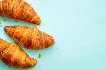 Croissant at blue background. French bakery. Flat lay image with copy space.