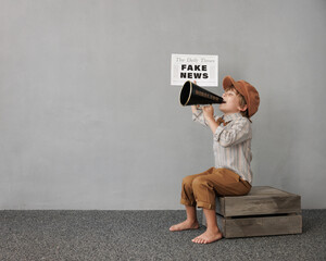 Newsboy shouting against grunge wall background. Boy selling fake news