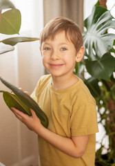 A little boy helps with cleaning around the house and taking care of the plants. Spring cleaning concept