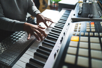 closeup shot of an unknown man playing the electronic piano, home studio. High quality photo