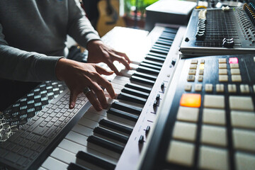 musician creating new music at the home studio, electronic piano, sound synthesizer and mixer. High...