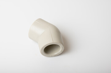 light PVC pipe tee, adapter connection for water isolated on light background, close-up