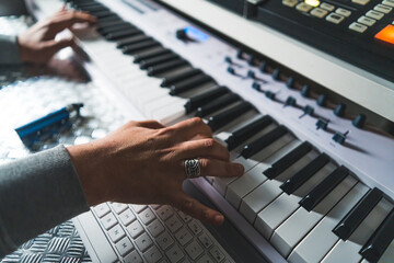 Fototapeta na wymiar shot of man's hands playing the electronic piano connected with a sound recording device. High quality photo