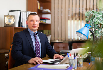 Confident man entrepreneur working with papers in business office